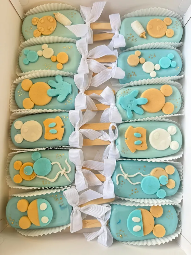Paletas de torta celestes decoradas para baby shower con cintas blancas