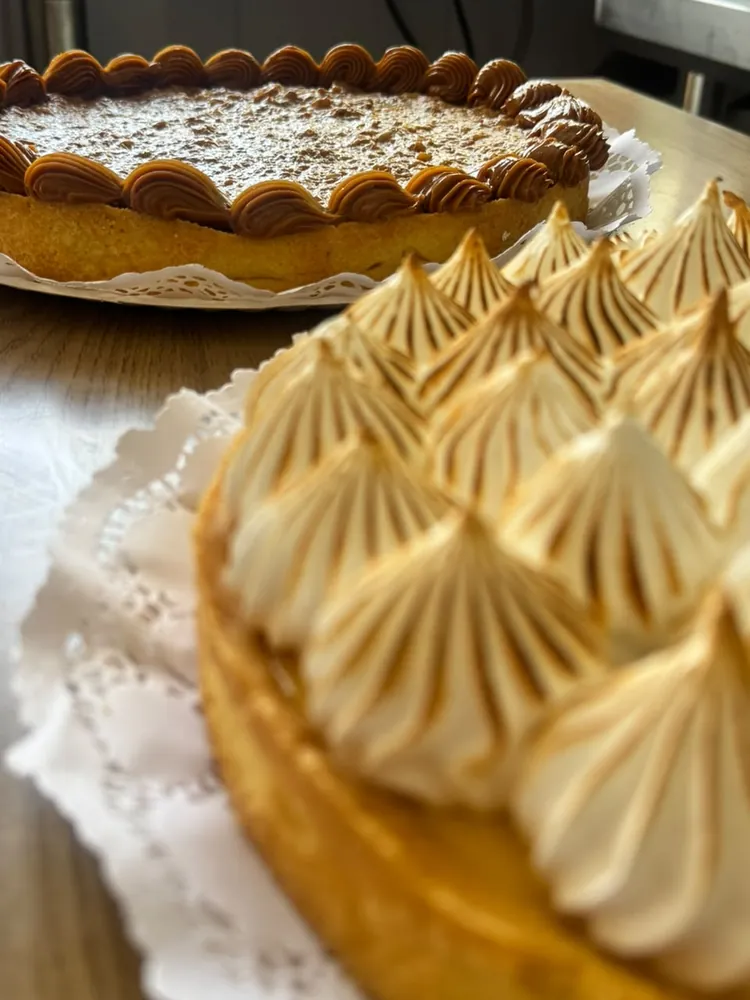 Pie de limón con merengue gratinado y tartaleta de manjar al fondo